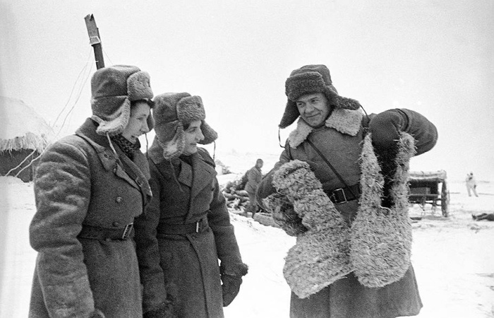Красноармеец показывает немецкие эрзац-валенки из соломы. ¦Фото: ВКонтакте.