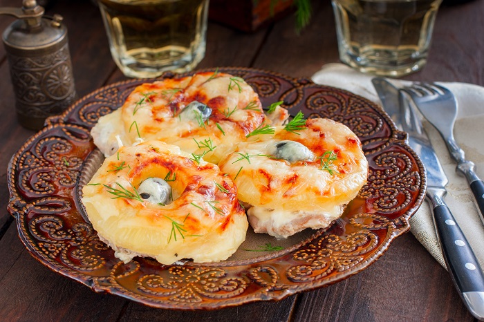 Положите кружочки ананасов сверху на свинину. / Фото: avangard-catering.ru Положите кружочки ананасов сверху на свинину. / Фото: avangard-catering.ru