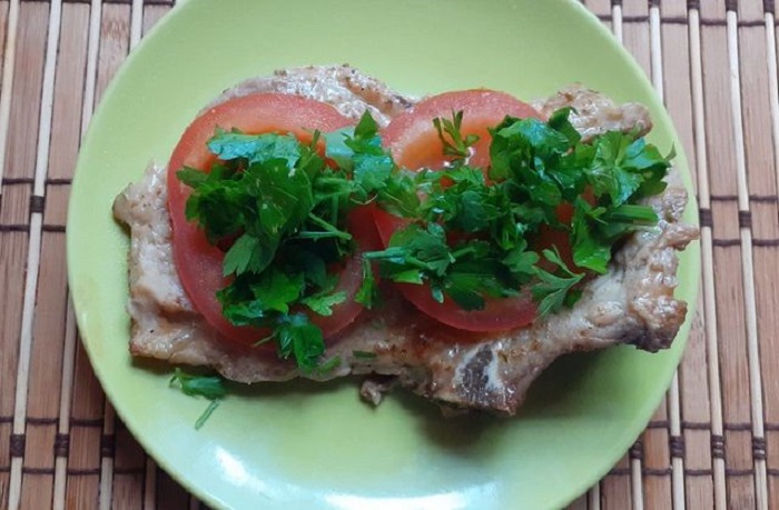 Положите на мясо колечки помидоров